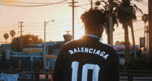 a man wearing a black balenciaga jersey with the number 10 on it