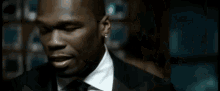 a man in a suit and tie is looking at the camera .