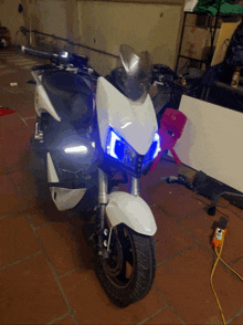 a white motorcycle has blue lights on the front
