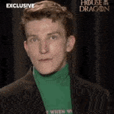 a man wearing a green turtleneck and a black jacket with the words exclusive house of the dragon on the bottom