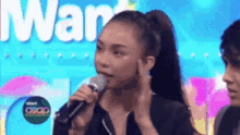 a woman is singing into a microphone with the word war in the background