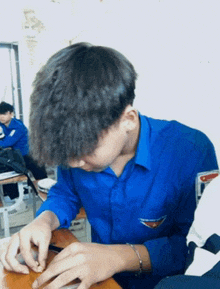 a boy in a blue shirt has a badge on his pocket that says ' a '