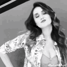a black and white photo of a woman in a floral shirt .