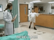 a woman in a hospital gown is dancing in front of a doctor who is holding a clipboard .