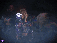 a group of people are dancing in front of a blue light