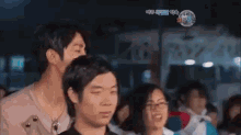 a man and a woman are standing next to each other in a crowded room .