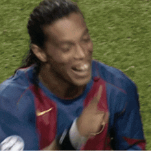 a soccer player wearing a nike shirt is pointing at the camera