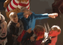 a man in a blue jacket is holding a bottle of ketchup in front of a crowd of people