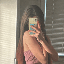 a woman taking a picture of herself with her phone