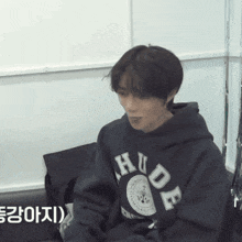 a young man wearing a hoodie that says hude on it