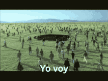 a large group of people are walking in a field with yo voy written in white