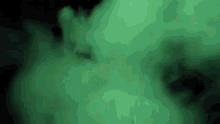 a green smoke coming out of a bottle on a black background .