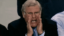 a man wearing glasses and a suit is making a funny face