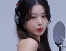 a woman wearing headphones and a microphone makes a funny face