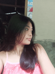 a woman in a pink tank top is looking at something