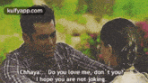 a man and a woman are sitting next to each other and the man is asking the woman if she loves him .