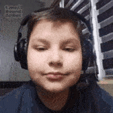 a young boy is wearing headphones and a microphone .