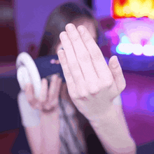 a person covering their face with their hands while holding a controller