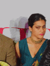 a woman wearing a necklace and a plunging neckline looks at something