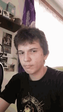 a young man is wearing a black shirt with a picture of a cow on it