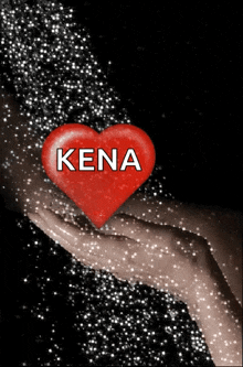 a hand holding a red heart with the word kena on it
