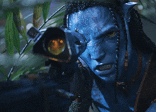 a man with a blue face is holding a camera in his hand