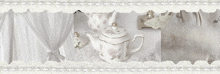 a white teapot sits on a table with a white lace border around it