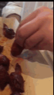 a close up of a person holding a piece of food on a table