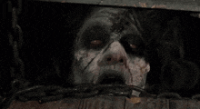 a close up of a zombie 's face coming out of a hole in a wooden box .