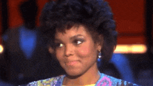 a close up of a woman wearing earrings and a sequined shirt