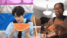 a man is eating a watermelon next to a woman eating a hot dog
