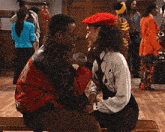 a man and woman are sitting on a bench and the man is wearing a red jacket with the letter r on the back