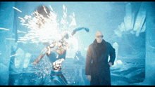 a man in a black coat is standing in front of a robot with sparks coming out of it