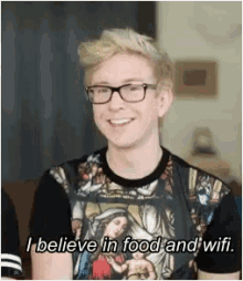a man wearing glasses and a t-shirt that says i believe in food and wifi .