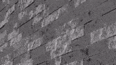 a black and white photo of a brick wall with a geometric pattern