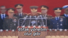 a group of military men are standing in front of a podium with the words ittifak yonetim olur gibi
