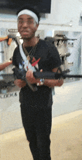 a man holding a gun in front of a wall that says lock &