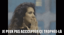 a woman praying with the words je peux pas accepter ce trophee-la written below her