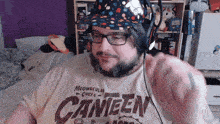 a man wearing headphones and a shirt that says canteen