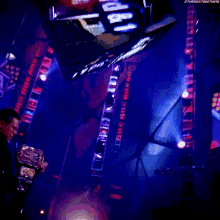 a man in a leather jacket is holding a wrestler 's belt