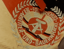 a red and white emblem with the words der arbeiter-und-bauernmacht on it