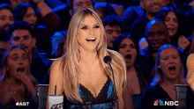 a woman sitting in front of a microphone with a cup that says agt