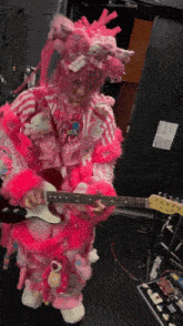 a person in a pink and white outfit playing a guitar