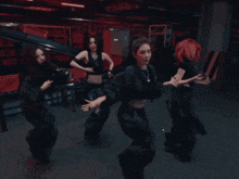 a group of women dancing in a dark room with red hair