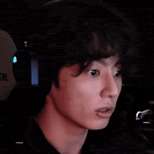 a close up of a person wearing headphones and making a face .