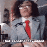 a man in a suit and tie is sitting at a desk and says `` that 's another day added '' .