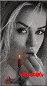 a black and white photo of a woman with a red candle and the words goodnight