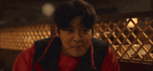 a young man wearing a black hoodie with a red letter s on the front