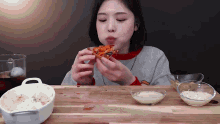 a woman is sitting at a table eating a pizza