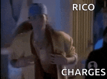 a man in a baseball cap is running in a room with the words rico charges written on the bottom .